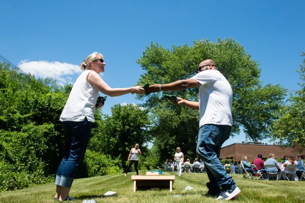 Stoke employees at company outing playing cornhole game